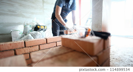 Male builder hand in gloves holding 114899534