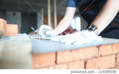 Male builder in yellow hard hat holds Male builder in yellow hard hat holds 114899598