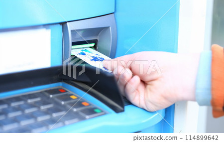 Male hand hold credit card aganist ATM 114899642