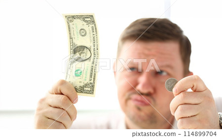 Arms of thoughtful man holding paper and coin currency 114899704