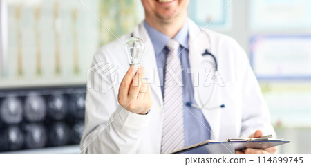 Male doctor hand holding lightbulb as bright idea invention symbol Male doctor hand holding lightbulb as bright idea invention symbol 114899745