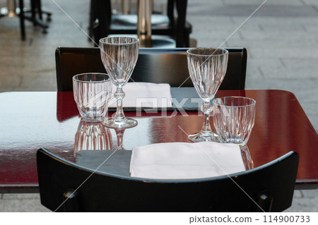 Table setting with crystal glasses and napkins Table setting with crystal glasses and napkins 114900733