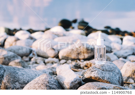 Clear dropper bottle on rocky lakeshore Clear dropper bottle on rocky lakeshore 114900768