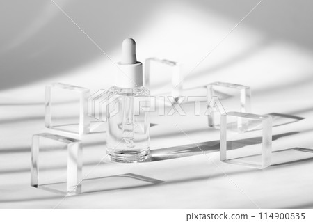 Serum cosmetic bottle mockup on acrylic transparent solid block pedestal on white background, shadow from sun, natural light from windows. Geometric stand, podium for cosmetics Serum cosmetic bottle mockup on acrylic transparent solid block pedestal on white background, shadow from sun, natural light from windows. Geometric stand, podium for cosmetics 114900835