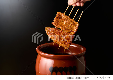 用醬汁浸泡鰻魚kabayaki 用醬汁浸泡鰻魚kabayaki 114901886