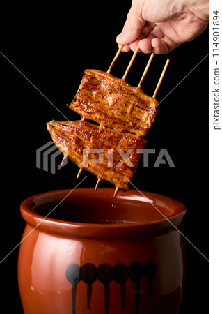 Soak eel kabayaki in sauce 114901894