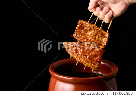 用醬汁浸泡鰻魚kabayaki 用醬汁浸泡鰻魚kabayaki 114901896