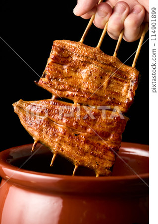 Soak eel kabayaki in sauce 114901899