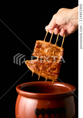 用醬汁浸泡鰻魚kabayaki 用醬汁浸泡鰻魚kabayaki 114901900