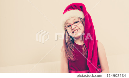 Smiling christmas girl in santa hat festive outfit 114902384