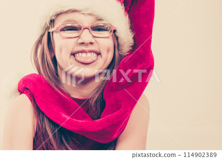 Girl in santa hat making silly face Girl in santa hat making silly face 114902389