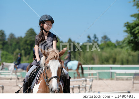 Kids enjoying horseback riding Kids enjoying horseback riding 114904935