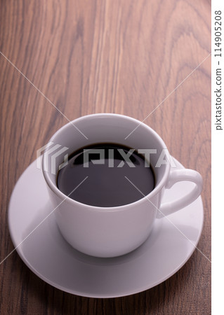 Black coffee in a white cup placed vertically on a wooden table Black coffee in a white cup placed vertically on a wooden table 114905208