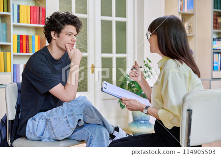 Psychologist working with young male college student in educational office Psychologist working with young male college student in educational office 114905503