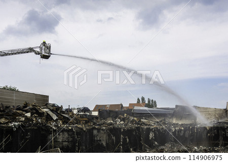 Firefighter putting out a fire in Zellik, Belgium 114906975