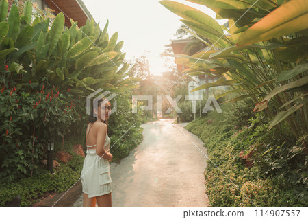 Beautiful asian woman walking and smiling in garden at resort Beautiful asian woman walking and smiling in garden at resort 114907557