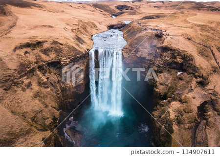 Aerial drone view of Majestic powerful Skogafoss waterfall flowing from cliff among brown mountain in autumn at Southern of Iceland Aerial drone view of Majestic powerful Skogafoss waterfall flowing from cliff among brown mountain in autumn at Southern of Iceland 114907611