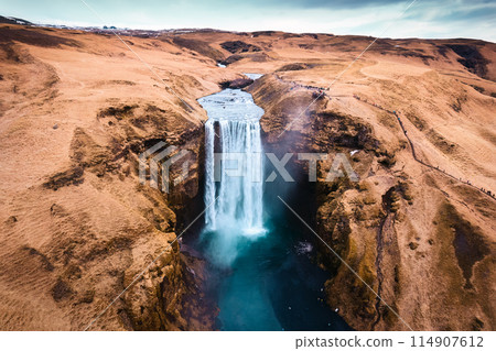 Aerial drone view of Majestic powerful Skogafoss waterfall flowing from cliff among brown mountain in autumn at Southern of Iceland 114907612
