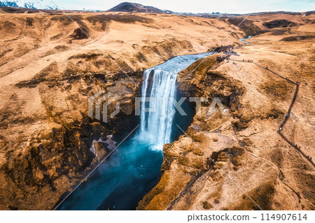 Powerful Skogafoss waterfall flowing with dry mountain in autumn at Iceland 114907614