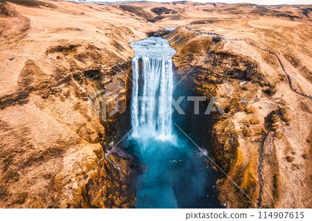 Powerful Skogafoss waterfall flowing with dry mountain in autumn at Iceland Powerful Skogafoss waterfall flowing with dry mountain in autumn at Iceland 114907615