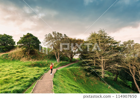 Female tourist enjoying on mountain with old growth forest and pathway in public park 114907650