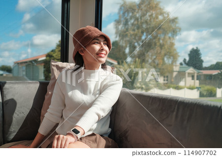 Happy asian woman enjoying with the view inside a motorhome Happy asian woman enjoying with the view inside a motorhome 114907702