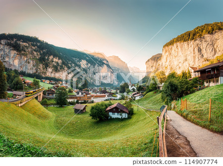 Lauterbrunnen valley with rustic village, famous church and Staubbach falls in the morning at Switzerland 114907774