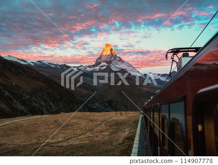 View from train with sunrise over Matterhorn mountain during ride up to Gornergrat station in Zermatt, Switzerland 114907778