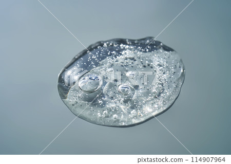 Pipette with serum shimmering in the sun on a blue background. Pipette with serum shimmering in the sun on a blue background. 114907964