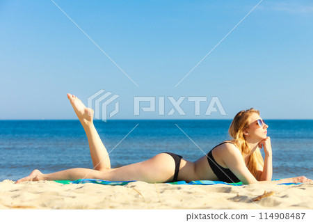 Summer vacation Girl in bikini sunbathing on beach Summer vacation Girl in bikini sunbathing on beach 114908487