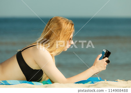 Woman in bikini sunbathing and relaxing on beach Woman in bikini sunbathing and relaxing on beach 114908488