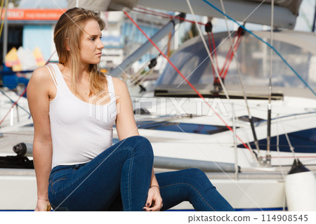 Attractive woman sitting on marina Attractive woman sitting on marina 114908545
