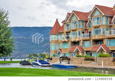 Luxury residential building with water channel and green lawn in front 114908556