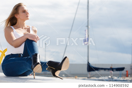 Woman sitting on marina Woman sitting on marina 114908592