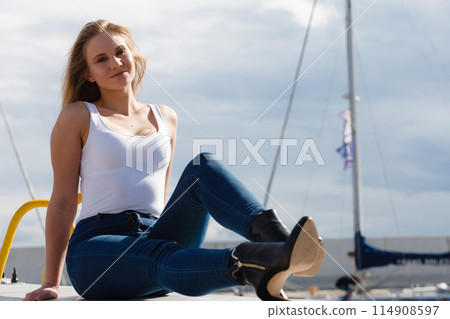 Woman sitting on marina Woman sitting on marina 114908597