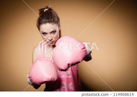 Female boxer wearing big fun pink gloves playing sports 114908614