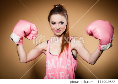 Female boxer wearing big fun pink gloves playing sports 114908622