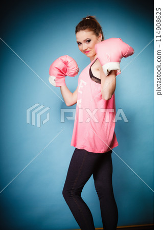 Female boxer wearing big fun pink gloves playing sports Female boxer wearing big fun pink gloves playing sports 114908625