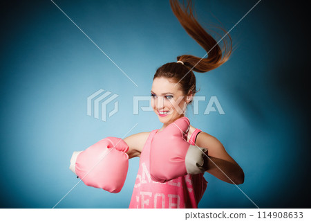 Female boxer wearing big fun pink gloves playing sports 114908633