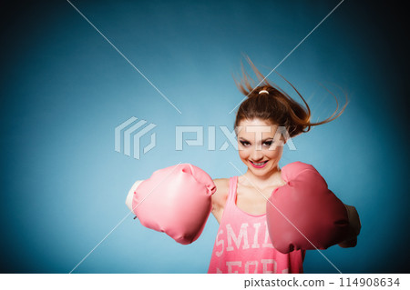Female boxer wearing big fun pink gloves playing sports 114908634