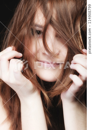 Young woman pulling her long hair. Young woman pulling her long hair. 114908799