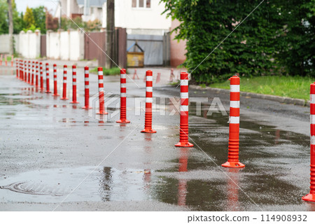 Road sign flexible plastic bollards with pedestrian white marking line and arrow sign on cement floor in parking car park area Road sign flexible plastic bollards with pedestrian white marking line and arrow sign on cement floor in parking car park area 114908932