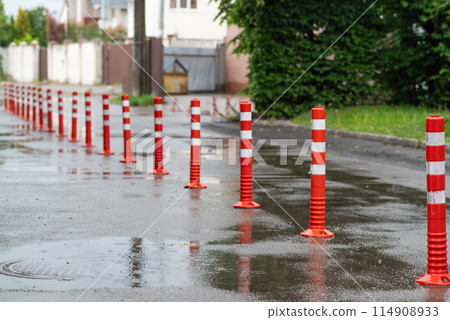 Road sign flexible plastic bollards with pedestrian white marking line and arrow sign on cement floor in parking car park area Road sign flexible plastic bollards with pedestrian white marking line and arrow sign on cement floor in parking car park area 114908933