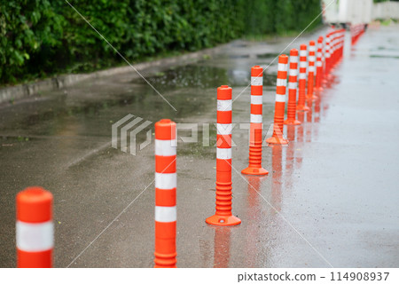 Road sign flexible plastic bollards with pedestrian white marking line and arrow sign on cement floor in parking car park area 114908937