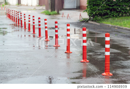 Road sign flexible plastic bollards with pedestrian white marking line and arrow sign on cement floor in parking car park area 114908939