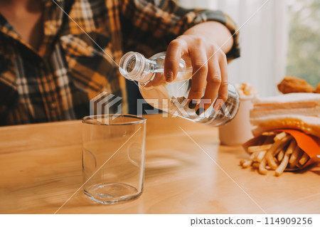 healthy beautiful young woman holding glass of water 114909256