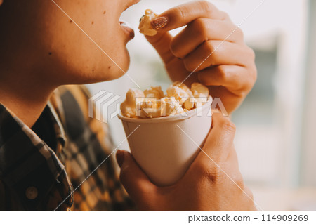 A woman holding a bowl of popcorn 114909269