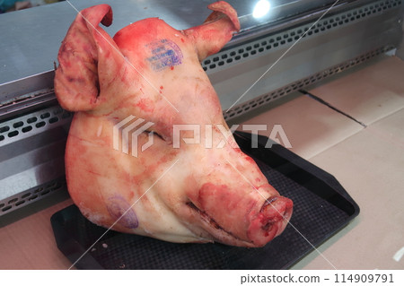 The head of the pig lies on the showcase of the meat department in the market 114909791