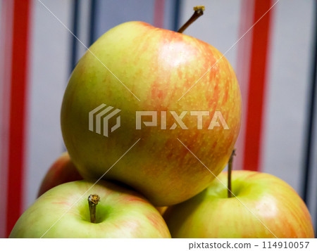 Stacked Apples. Fresh apples stacked, vibrant against a striped backdrop. Stacked Apples. Fresh apples stacked, vibrant against a striped backdrop. 114910057