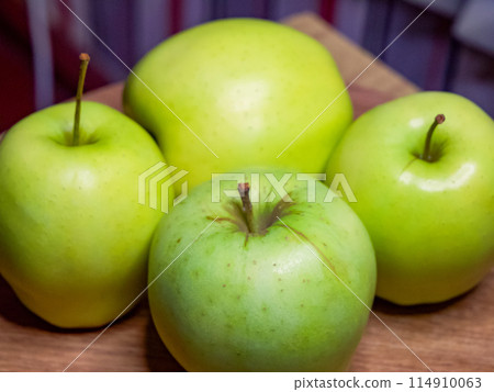 Bright green apples, arranged neatly, imply a focus on organic produce in a market setting. 114910063